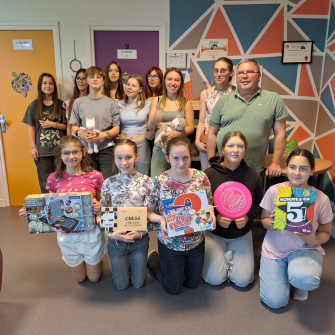 Les jeunes posent fièrement avec les nouveaux jeux de société